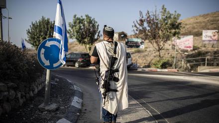 Ein israelischer Siedler trägt eine Waffe am Haupteingang der palästinensischen Stadt Nablus im besetzten Westjordanland. 