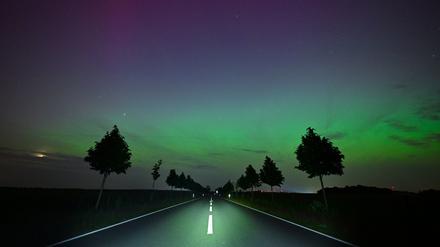 Hellgrün und ein wenig rötlich leuchten Polarlichter am Nachthimmel im Landkreis Märkisch-Oderland in Ostbrandenburg. Die Nordlichter (Aurora borealis) werden durch eine Wolke elektrisch geladener Teilchen eines Sonnensturms in der Erdatmosphäre erzeugt.