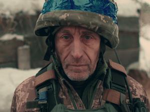 Nahaufnahme eines älteren ukrainischen Soldaten in Militäruniform und Helm. 