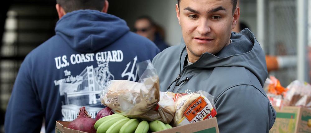 Ohne Lohn: Ein Mitarbeiter der US-Küstenwache in Kalifornien trägt eine Kiste mit kostenlosen Lebensmitteln nach Hause.