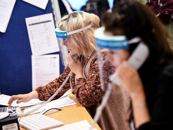 Ende April 2020: Mitarbeiterinnen eines Berliner Gesundheitsamtes telefonieren mit Gesichtsschutzschirm. Um die Papierflut zu begrenzen, führt das Amt ein Kontaktpersonen-Management-System ein.