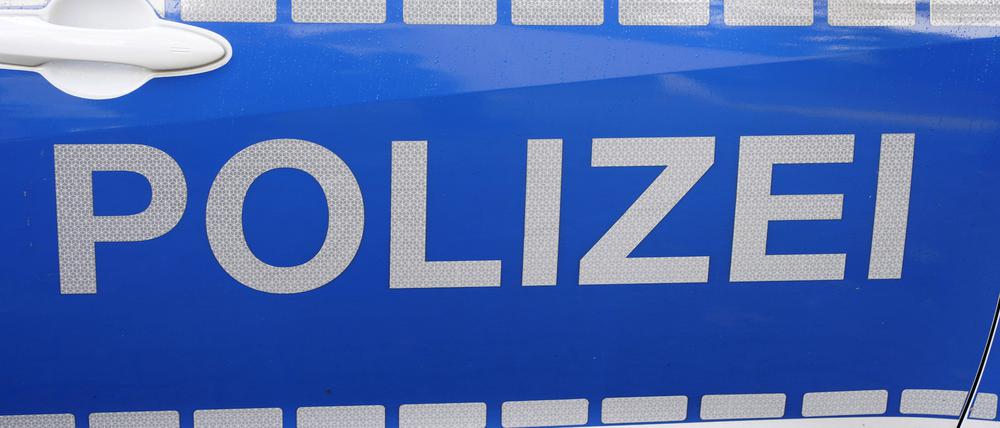 Schriftzug der Polizei an Poizeifahrzeug.