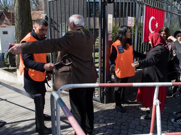 Türken stehen vor dem Eingang zum Wahllokal im Hof des türkischen Generalkonsulats in Berlin an einer Sicherheitskontrolle. Die Verfassungsreform würde dem Staatsoberhaupt in der Türkei deutlich mehr Macht verleihen.
