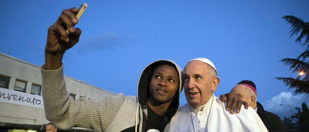 Franziskus macht die Angela. Nach dem Füßewaschen ist der Papst auch für ein Selfie mit einem Flüchtling zu haben.
