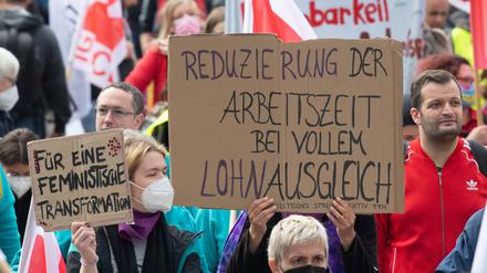 „Reduzierung der Arbeitszeit bei vollem Lohnausgleich“ steht auf dem Plakat einer Frau bei der Mai-Kundgebung der Gewerkschaften in Frankfurt am Main. 