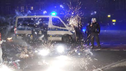 Polizisten stehen am Silvesterabend hinter explodierendem Feuerwerk. (Archivbild)