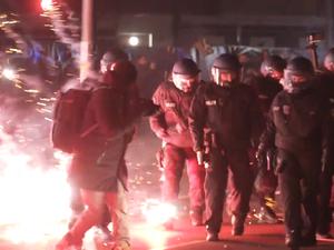 Einsatzkräfte der Polizei stehen in der Silvesternacht zwischen brennendem Feuerwerk in Neukölln. (Archivbild)