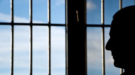 ARCHIV - 04.03.2015, NA, Heilbronn: Ein Gefängnisinsasse sitzt in einer Justizvollzugsanstalt vor einem vergitterten Fenster. (zu dpa: «Dreistellige Zahl an Häftlingen kann im Saarland wählen») Foto: Daniel Naupold/dpa +++ dpa-Bildfunk +++
