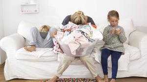 Eine erschöpfte Mutter neben ihren Kindern.