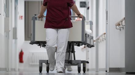 Eine Krankenpflegerin und ein Krankenpfleger schieben ein Krankenbett durch den Gang einer Station eines Krankenhauses (Symbolbild).
