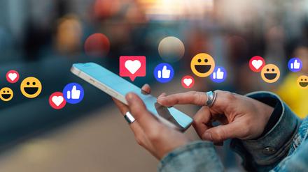 Weibliche Hände halten ein Mobiltelefon.