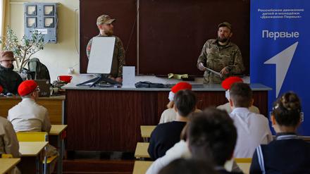 Russische Soldaten demonstrieren Schulkindern ein Starlink-Terminal in der Region Donezk am 11. April 2025.