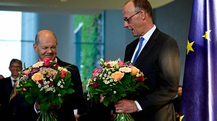 Der neue Bundeskanzler Friedrich Merz (R) und sein Vorgänger Olaf Scholz.