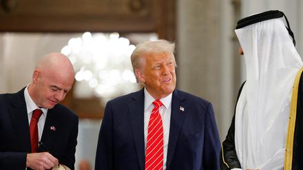 Fifa-Präsident Gianni Infantino schreibt auf einen Fußball, während er an einer Veranstaltung mit dem Emir von Katar, Tamim bin Hamad Al Thani, und dem US-Präsidenten Donald Trump im Lusail Palace in Lusail, Katar, teilnimmt.