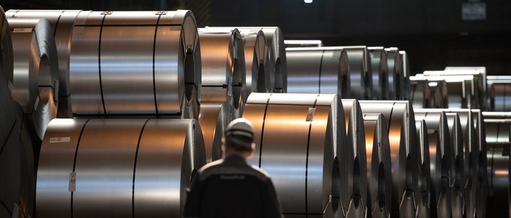 Ein Mitarbeiter von Thyssenkrupp läuft im Duisburger Werk vor Stahl-Coils entlang (Symbolbild).