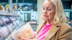 Eine Frau betrachtet in einem Supermarkt Tiefkühlfleisch (Symbolbild).