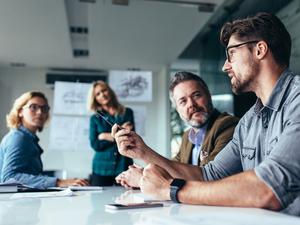Kollegen besprechen sich im Teammeeting.