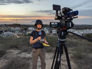 Sophie von der Tann, Korrespondentin im ARD-Studio Tel Aviv, berichtet im Oktober 2023 live aus Sderot. Einen Kilometer entfernt im Hintergrund liegt die Grenze zum Gazastreifen.