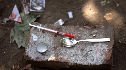 Drogenbesteck eines Fixers - Einwegspritze und Löffel wurden nach dessen Gebrauch auf einem Stein hinterlassen.