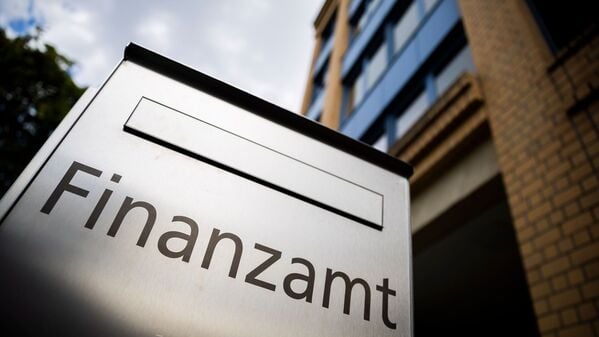Ein Briefkasten des Finanzamtes steht vor einem Gebäude.