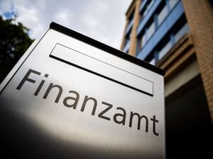 Ein Briefkasten des Finanzamtes steht vor einem Gebäude.