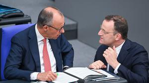 Bundeskanzler Friedrich Merz (links) unterhält sich mit Jens Spahn, dem Vorsitzenden der Unionsfraktion, im Bundestag.