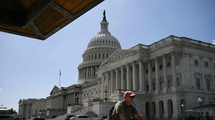A man cycles past the the US Capitol in Washington, DC, on September 18, 2025. (Photo by Oliver Contreras / AFP)