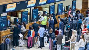 Zahlreiche Fluggäste warten vor den Check-in-Schaltern im Terminal 1 des Flughafens Berlin Brandenburg.