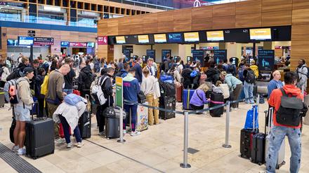 Zahlreiche Fluggäste sind vor den Check-in-Schaltern im Terminal 1 des Flughafens Berlin-Brandenburg unterwegs.