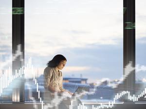 Eine Frau am Laptop, im Vordergrund Charts