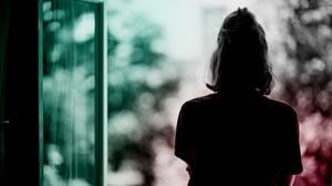 Eine Frau steht am Fenster