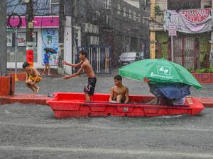 Nach starkem Regenfall spielen Kinder mit einem verlassenen Rettungsboot in Quezon City, ein der eingemeindeten Metropolen von Manila, der Hauptstadt der Philippinen.