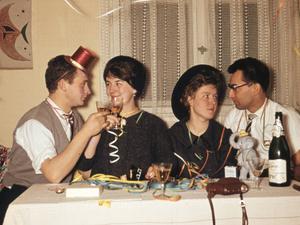 Lockerungsübungen mit Alkohol: Paare stoßen 1958 bei einer Silvester-Party miteinander an.