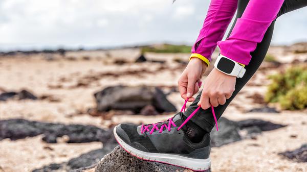 Eine Frau schnürt sich die Laufschuhe (Symbolbild).