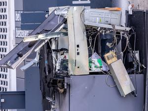 Ein gesprengter Geldautomat steht vor einem Getränkemarkt und wird von der Polizei untersucht.