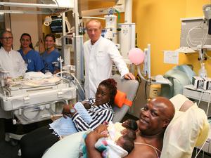 Credit: Berliner CharitéInfo 1: Vorne v. l.: Prof. Wolfgang Henrich, Direktor der Klinik für Geburtsmedizin, die Eltern mit vier Kindern. Hinten v. l.: Neonatologin Dr. Monika Berns, Gesundheits- und Kinderkrankenpflegerin Jessica Blauert und Jasmin Barthel, Studentin der Hebammenwissenschaften. Kind Nummer fünf liegt im Inkubator.