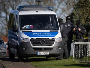 Polizeibeamte stehen bei einer Hausdurchsuchung vor einem Wohnhaus in Reimershagen.