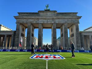 Am Brandenburger Tor ist Kunstrasen ausgerollt – hier können sich Fans im Flag Football (eine Variante des American Football) ausprobieren.