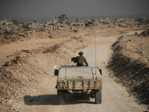 Israelische Sicherheitskräfte fahren während einer von der israelischen Armee organisierten Tour für Journalisten an den Ruinen von Gebäuden im Gazastreifen vorbei.