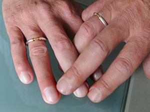 Ein homosexuelles männliches Paar hält die Hände zusammen.