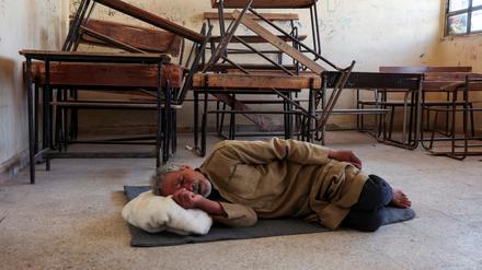 Ein Mann ohne Unterkunft schläft in einer Schule in Syrien.