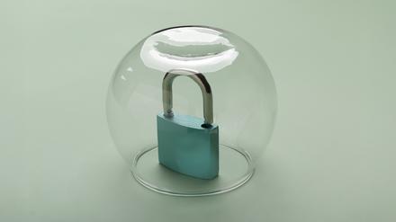 Ein Vorhängeschloss steht unter einer Glaskuppel.