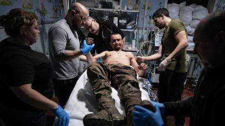 11.11.2025, Ukraine, Gebiet Donezk: Auf diesem Foto leisten Sanitäter dem verwundeten Soldaten Oleg Solontschak an einem Stabilisierungspunkt in der Nähe von Kostjantyniwka in der Region Donezk erste Hilfe.