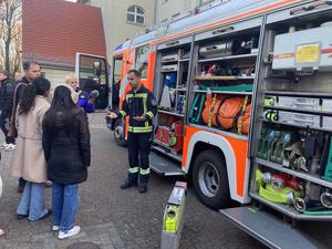 Feuerwehrmann Marcel stellt an der Alfred-Nobel-Schule das Feuerwehrfahrzeug vor.