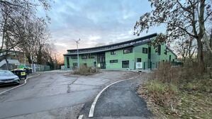 Jugendclub Wildwuchs in Berlin Spandau, fehlende Straße vor dem Neubau - Kunst am Bau (das Windrad mit Stein und Wasser).