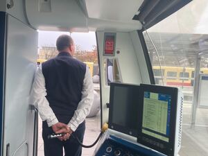 Stefan Lemke macht per Mikrofon eine Ansage, während die Fahrgäste einsteigen.