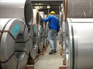 Industriearbeiter bei der Inspektion eines großen Metallrohrs in einer Fabrik (Symbolbild).