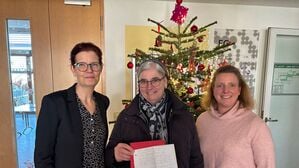 Die Vorständin des Sozialdienstes katholischer Frauen der Diözese Rottenburg-Stuttgart, Svenja Gruß (l), steht neben Schwester Nicola Maria, und Daniela Kob (r), Einrichtungsleiterin Paulusstift. Schwester Nicola Maria hält den Spendenbrief eines Obdachlosen aus Stuttgart in der Hand, der 200 Euro an Mütter in Not gespendet hat.