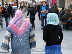 Zwei Frauen mit Kopftuch sind von hinten zu sehen (Symbolbild)