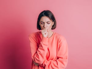 Illustration: Eine Frau hustet in ihre Hand.